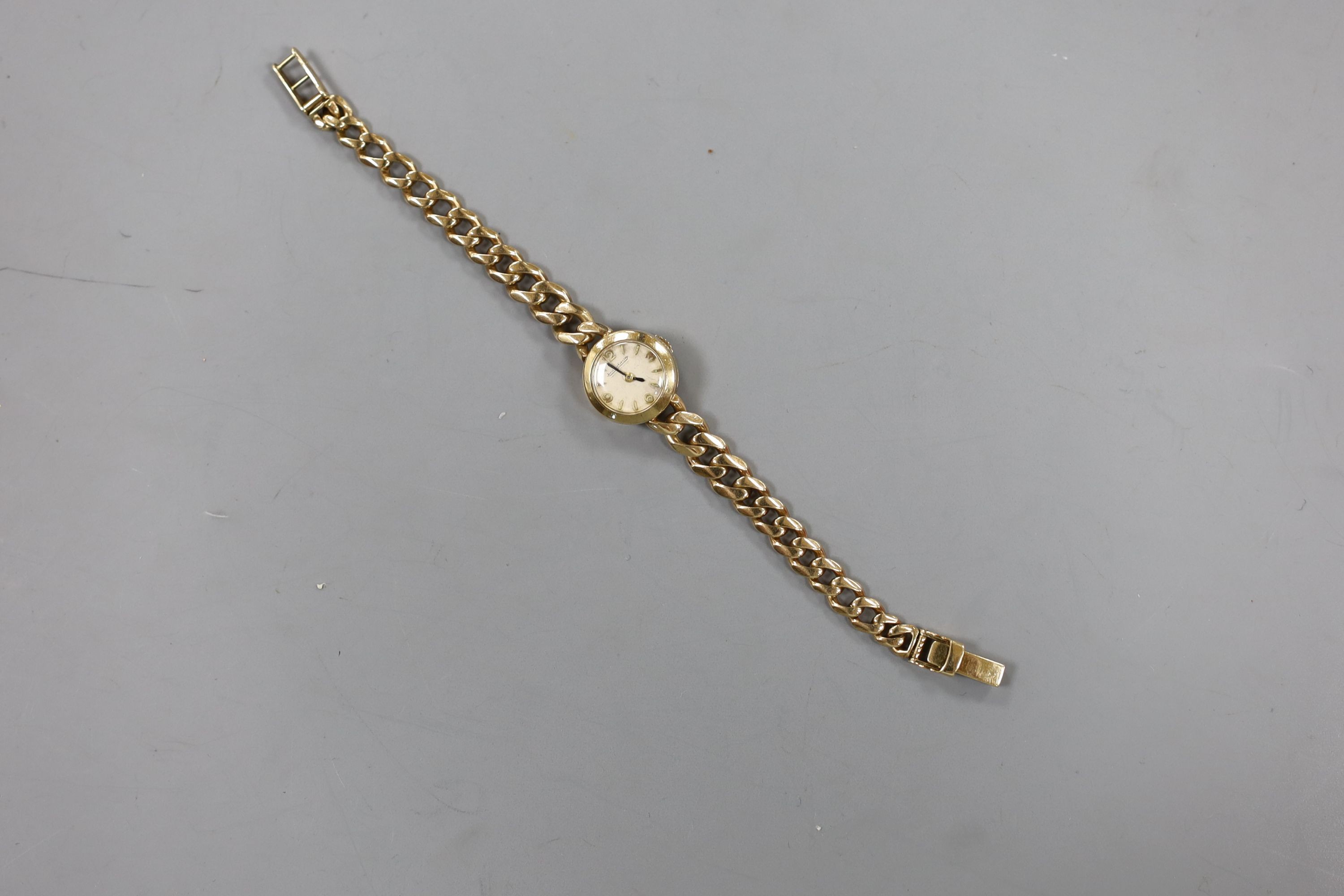 A lady's 1960's 9ct gold Jaeger Le Coultre back wind wrist watch, on a 9ct gold curb link bracelet